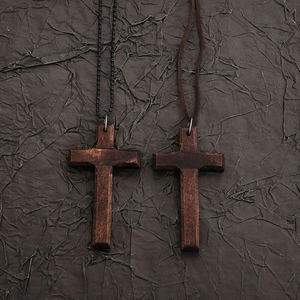 Detailed macro view of dark wooden gothic cross pendants with vintage textures and beads
