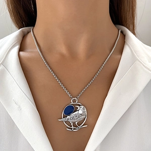 Antike silberne Kolibri-Kette mit blauem Stein-Anhänger auf weißem Hemd