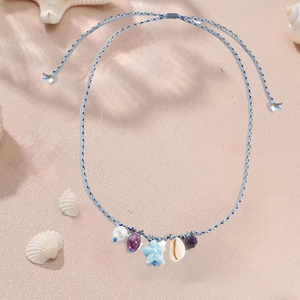Dettaglio della collana in corda intrecciata con stelle marine, conchiglie e ciondoli