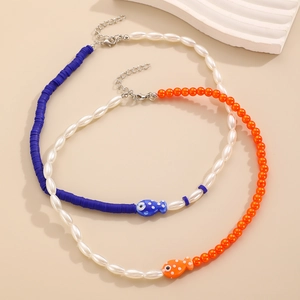 Dettaglio di ciondoli a forma di pesce in ceramica e perline su collane estive boho