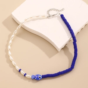 Dettaglio della collana con perle, ciondolo a pesce blu e perline colorate