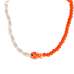 Detail of bohemian necklace featuring bicolor orange beads and a ceramic fish pendant