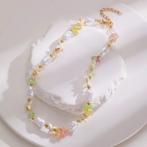 Collana boho con perline, stella marina e conchiglie su supporto in pietra