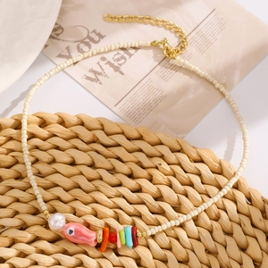 Dettaglio collana bohémien con ciondolo a forma di pesce rosa e perle colorate