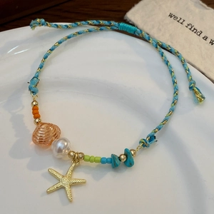Dettaglio della collana a tema oceano con ciondolo a stella marina e cordino intrecciato