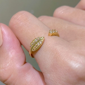 Macro detail of adjustable gold leaf and crown ring with shimmering pave zircons