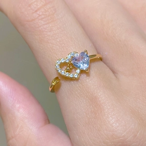 Macro view of gold heart arrow ring with purple gemstone and sparkling zircon stones
