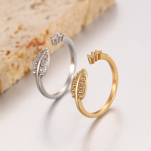 Close-up of gold and silver leaf open rings with sparkling cubic zirconia inlay