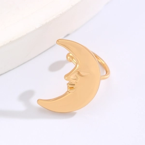 Detailed close-up of golden crescent moon face ear cuff with polished metallic finish