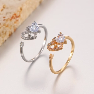 Detail of adjustable heart and arrow rings with cubic zirconia in gold and silver finish