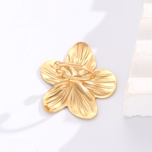 Detailed side view of a gold five-petal flower ear clip with radial textured mirror finish