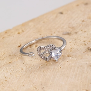 Macro shot of silver cupid arrow ring with heart-shaped cubic zirconia and stones