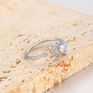 Macro shot of Cupid's arrow ring featuring heart-shaped zircon with micro-pave setting