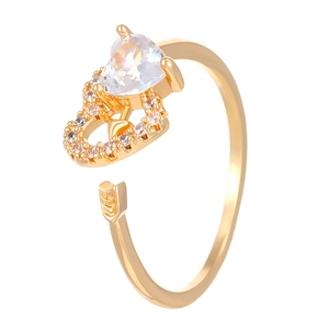 Detailed macro view of S925 engraved gold Cupid arrow ring with heart-cut cubic zirconia