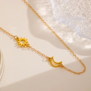 Detailed close-up of golden necklace chain with celestial sun and moon hollow pendants