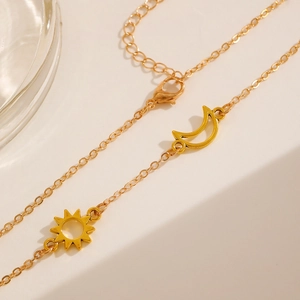 Macro detail of sun and moon pendant necklace set in golden stainless steel