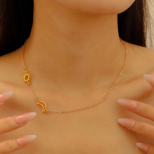 Detailed view of gold stainless steel necklace featuring sun and moon pendants on a model