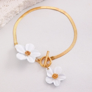 Détail du collier à chaîne serpent dorée avec pendentifs fleurs blanches et fermoir à bascule