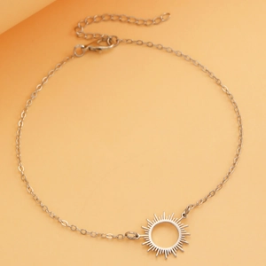 Detail view of a silver sun pendant necklace with a fine chain and lobster clasp closure
