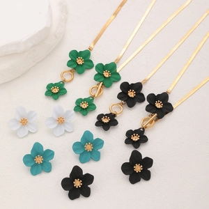 Gros plan de pendentifs fleurs mats et de boucles d'oreilles en plusieurs couleurs vives