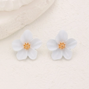 Détail de boucles d'oreilles fleurs bleu clair et blanc avec d'élégants pistils dorés