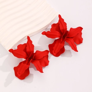 Macro shot of red 3D floral earrings with matte finish and artistic wavy petal texture