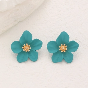 Vue macro détaillée de boucles d'oreilles fleurs bleu canard mat et cœurs dorés