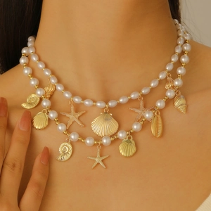Gros plan du collier de perles bohème à deux rangs avec breloques dorées d'étoile de mer et coquillage