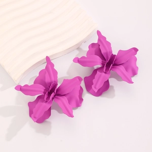 Detail view of purple matte lacquered flower earrings with 3D pleated petals on a display