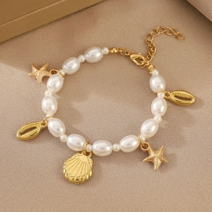 Détail du collier thème marin avec pendentifs étoile de mer dorés et perles blanches