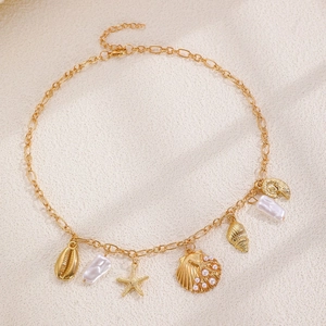Collier doré avec pendentifs étoile de mer et coquillage, perles sur tissu texturé