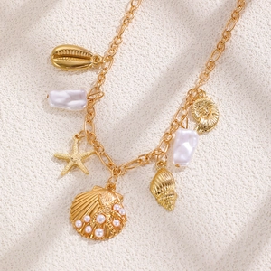Collier doré avec étoile de mer, coquillages et perles naturelles au style chic