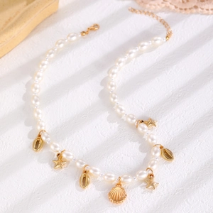 Détails de charmes étoile de mer dorée et coquillages sur collier de perles de plage