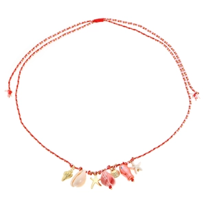 Dettaglio macro della collana in corda intrecciata con conchiglie dorate, stelle e pesci