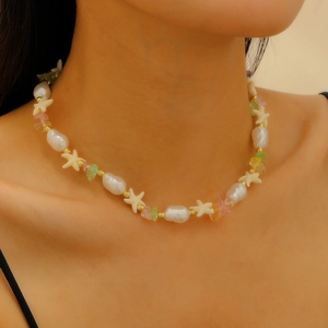 Dettaglio di collana boho con perle barocche, pietre colorate e ciondoli a stella marina