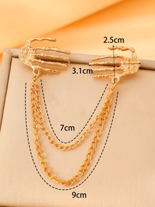 Detail of vintage gold skeleton hand brooch with double chains and rhinestone accents