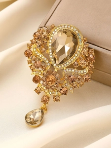 Detail of vintage gold crystal brooch with champagne rhinestones and pear-shaped pendant