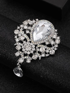 Macro shot of vintage silver brooch with teardrop crystal and intricate diamond setting