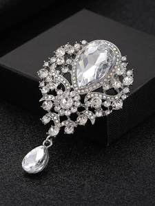 Macro shot of silver alloy brooch with clear rhinestones and pear-shaped pendant