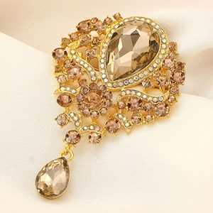 Vintage gold-tone crystal brooch with champagne teardrop stones on soft satin