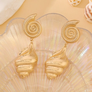 Detailed macro shot of golden ocean-inspired earrings with starfish and seashell designs
