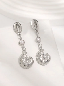 Macro detail of ocean theme earrings with silver shell, white pearl and nautilus pendant