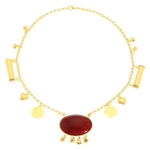 Detail of vintage gold necklace with carnelian pendant and metallic charms