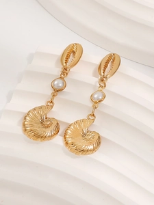 Detailed macro view of golden starfish and conch earrings with elegant white pearl accents