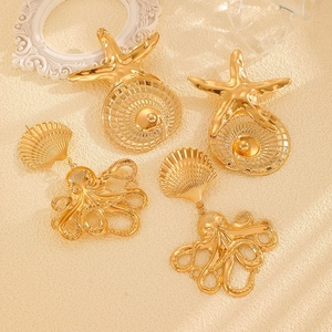 Detail of gold starfish and octopus earrings featuring intricate ocean shell patterns