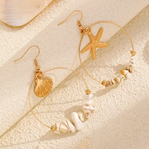 Detailed view of gold ocean-themed hoop earrings with starfish, shell charms and white stones
