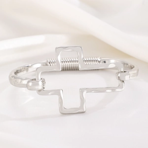Detailed macro view of silver alloy bracelet with hammered texture and cross design