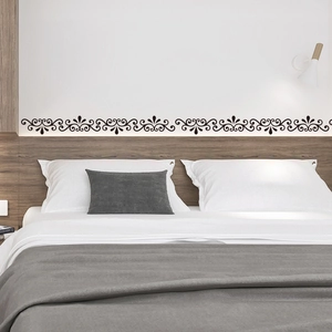 Détail de la bordure murale noire à motif de vigne sur un mur de chambre blanc