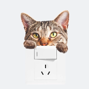 Detail of cute tabby cat wall sticker peeking over a white light switch socket