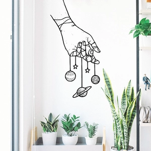 Minimalist black line art wall sticker featuring hanging planets and stars on white wall
